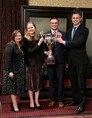 (L-R) Judge Elrod, of Appeals for the Fifth Circuit presenting the finalist trophy to Katrin Kelley, Shawn Brew, and Jake Putala